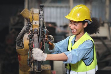 Koruma üniformalı mühendis veya işçi ayakta ve onarım veya ağır sanayi imalat fabrikasında güvenlik başlığı ile endüstri makine süreci kontrol