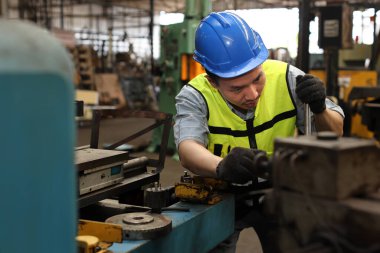 Koruma üniformalı mühendis veya işçi ayakta ve onarım veya ağır sanayi imalat fabrikasında güvenlik başlığı ile endüstri makine süreci kontrol