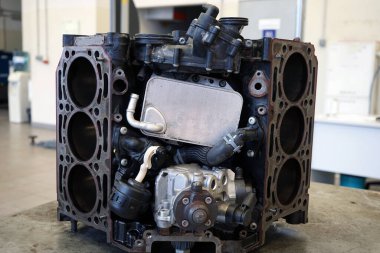 Kısmen parçalanmış motor, sorun çözme ve tamir için çalışma tezgahının üzerinde bulunuyor. Seçili odak.