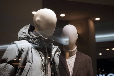 Moskova Rusya - Kasım 2021: Moda ve rahat kıyafetler satan bir mağazanın vitrininde, kalın kış kıyafetleri giymiş iki manken var..