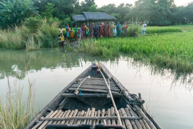 Küçük bir tekne sel kurbanlarını kurtarmak için nehir boyunca yol alıyor. Tekneye odaklanmış..