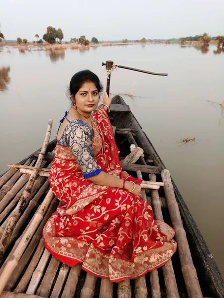 一位年轻美丽的印度姑娘的画像 穿着传统的莎丽服 坐在一条大河岸边的小船上 — 图库照片