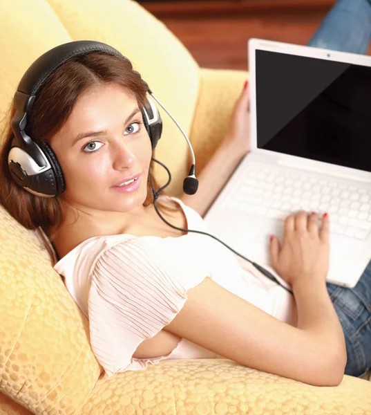 A woman working on a laptop sitting on sofa — Stock Photo, Image