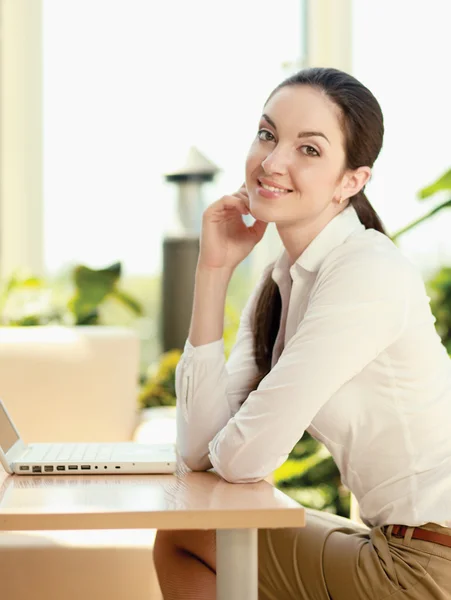 Bella donna felice seduta con computer portatile — Foto Stock