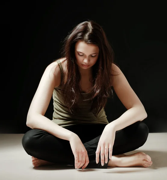 En ung kvinna som sitter på golvet — Stockfoto