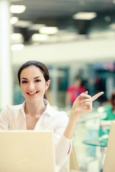 Close-up van een jong meisje met een laptop zitten aan de balie — Stockfoto