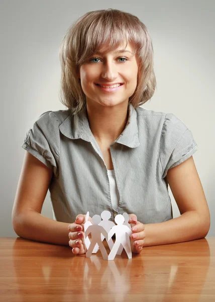 Junge Frau kümmert sich um Kette von Papiermenschen — Stockfoto