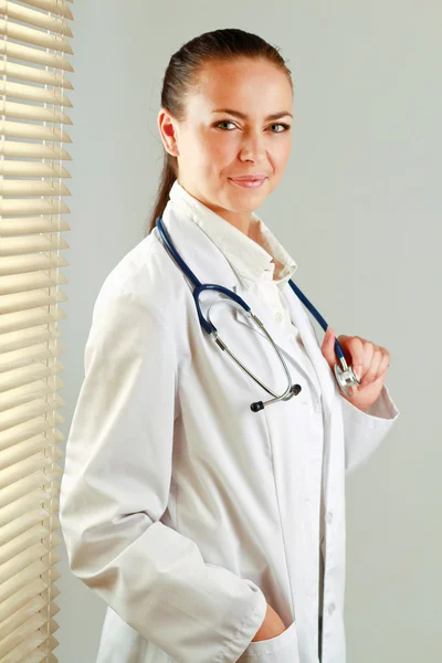 Lekarka, która stoi w pobliżu okna — Zdjęcie stockowe