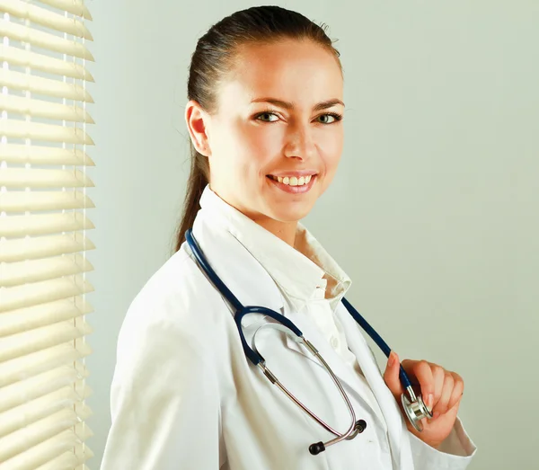 Женщина-врач стоит у окна — стоковое фото