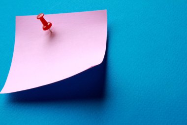 pembe kağıt Not izole mavi zemin üzerine.