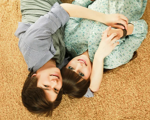 Jovem casal deitado no chão — Fotografia de Stock