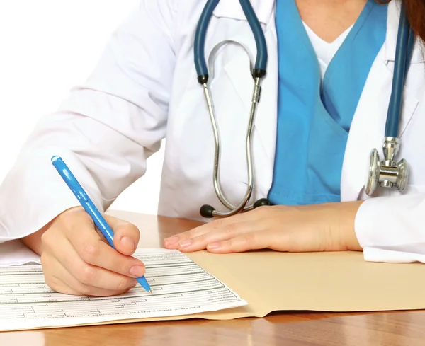 Doctora joven en el escritorio aislada — Foto de Stock