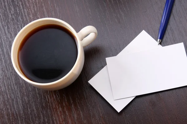 Una taza de café y tarjetas de visita en un escritorio — Foto de Stock