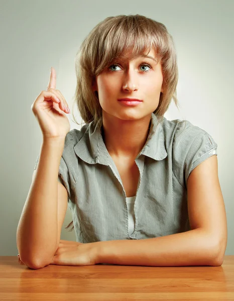 Pensive young woman sitting at the desk — Stock Photo, Image