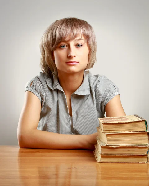 Young woman sitting on the desk — Stock Photo, Image