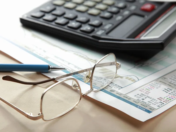 Pen and calculator on stocks — Stock Photo, Image