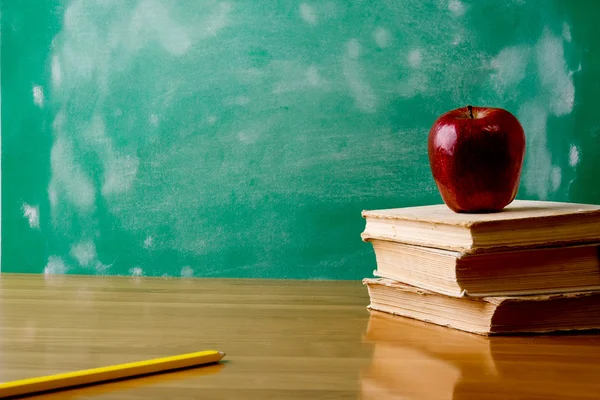 Ein Bleistift und ein roter Apfel auf einem Stapel Bücher — Stockfoto