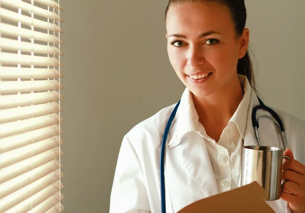 Šťastná žena lékaře stojí u okna — Stock fotografie