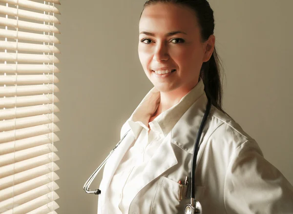 Femme médecin est debout près de la fenêtre — Photo