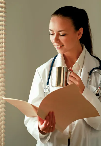 Vrouw arts is permanent in het kantoor in de buurt van venster — Stockfoto