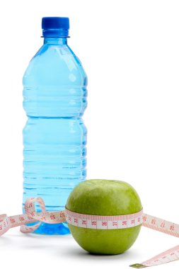 Yeşil elma, bir şişe su ve bir ölçüm bandı