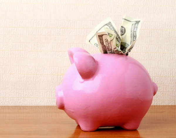 Piggy bank on a table with dollar — Stock Photo, Image