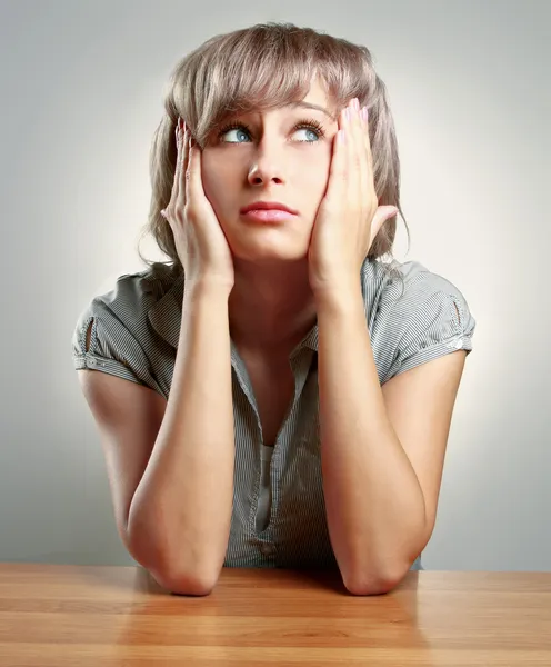 Jeune femme fatiguée assise au bureau — Photo