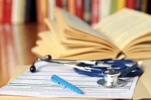 A stethoscope is lying with a book — Stock Photo, Image