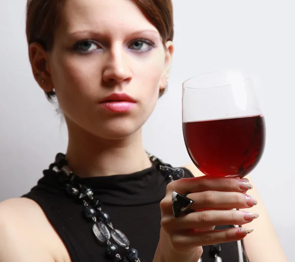 Женщина с бокалом вина возле стены — стоковое фото