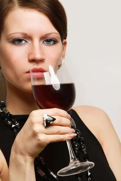 Женщина с бокалом вина возле стены — стоковое фото