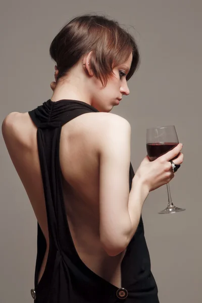 Femme avec un verre à vin près du mur — Photo