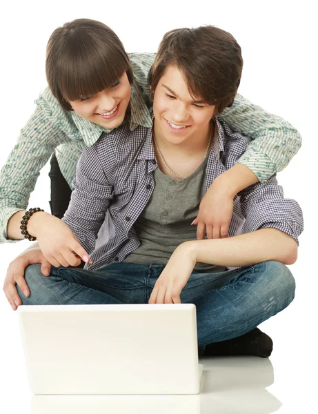 Couple sitting on the floor behind a laptop — Stock Photo, Image