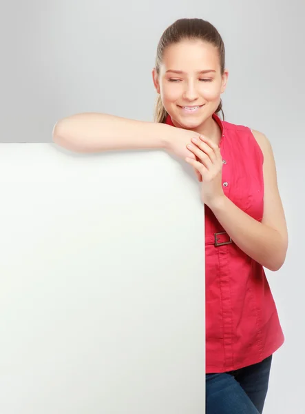 A smiling woman standing near blank — Stock Photo, Image