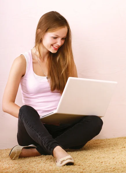 Junges Mädchen mit Laptop auf dem Boden sitzend — Stockfoto