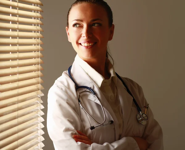 Femme médecin est debout près de la fenêtre — Photo