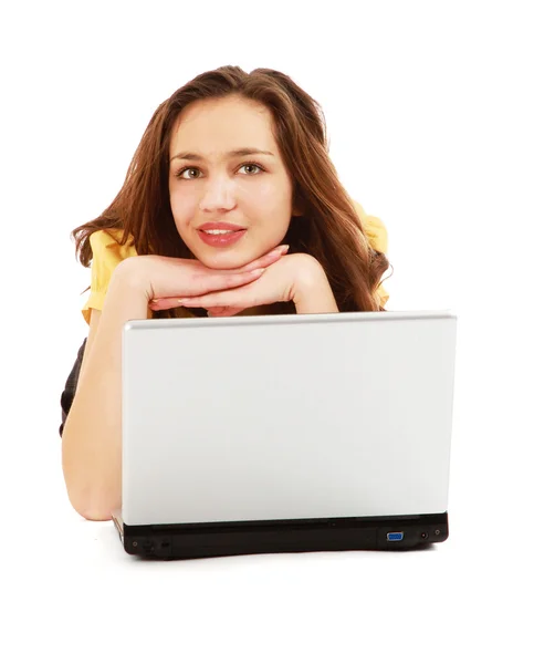 Una giovane donna sdraiata con un computer portatile — Foto Stock