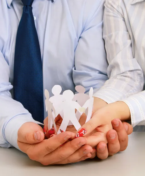 Las manos de los empresarios sosteniendo gente de papel — Foto de Stock