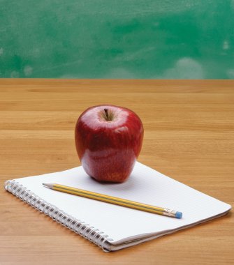 bir defter üstünde Kırmızı elma.