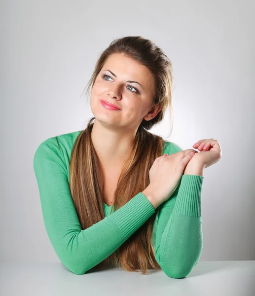 Frau sitzt isoliert auf grau — Stockfoto