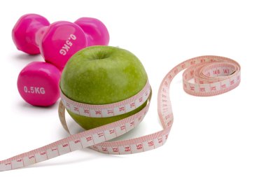 bir elma, bir ölçüm bandı ve dumbbell