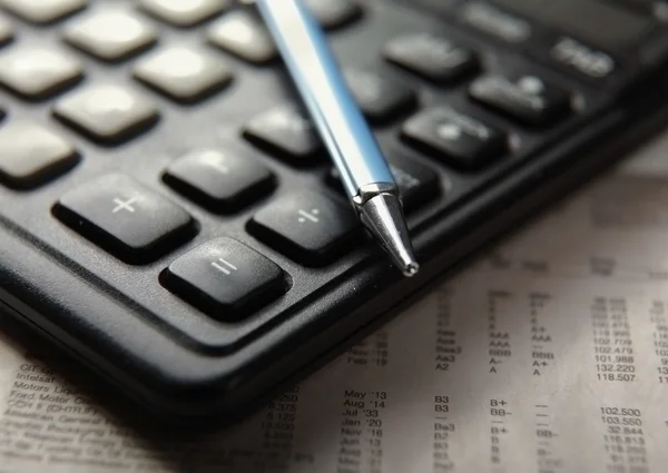 Close-up van pen en Rekenmachine op papier tabel nummers. — Stockfoto