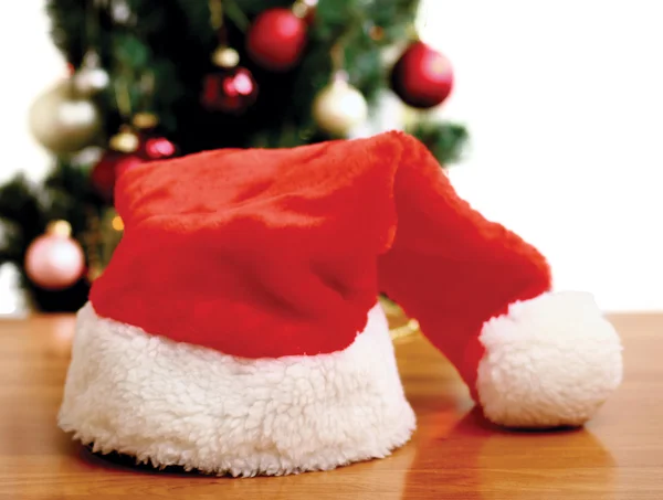 Santa hatt under en julgran — Stockfoto