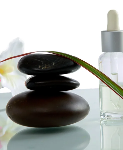 Botellas de aceite esencial y conjunto de piedras con flor —  Fotos de Stock