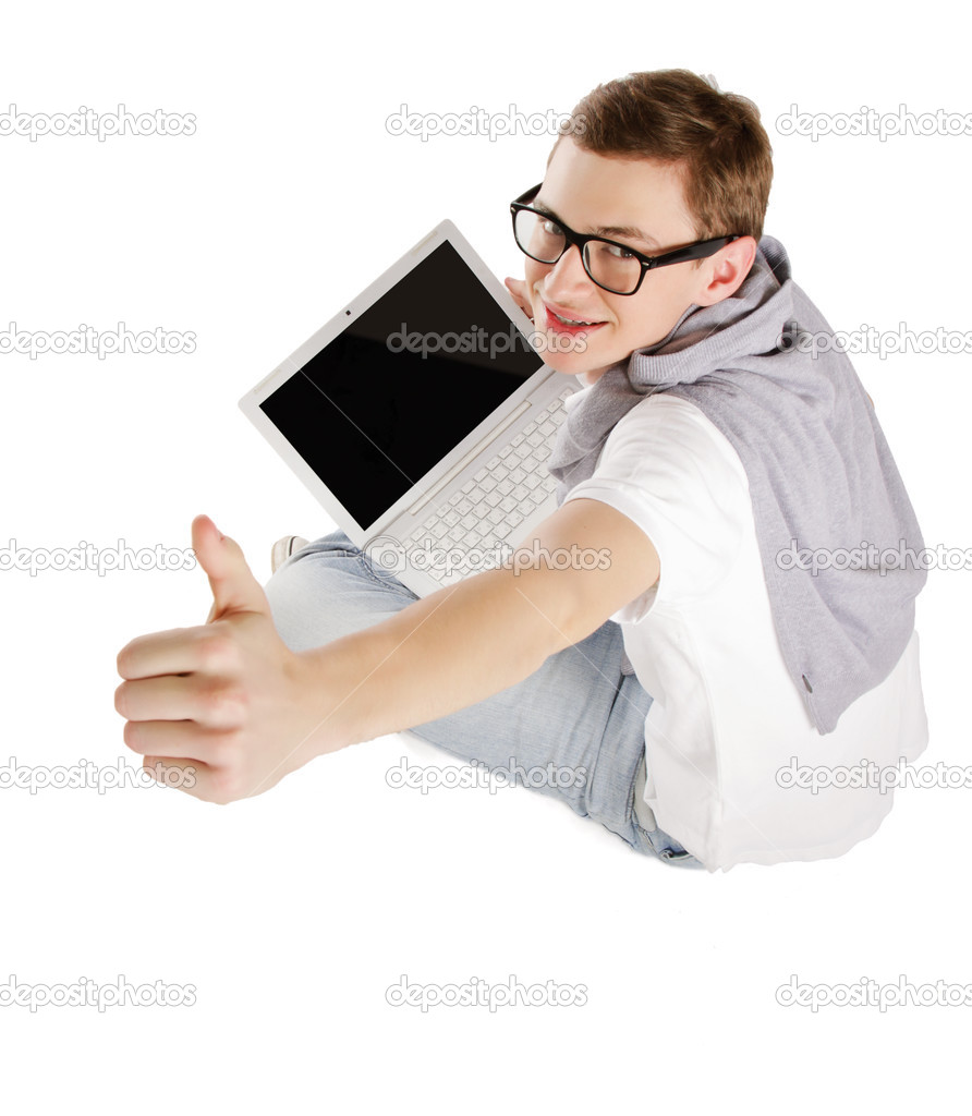 Young happy man with laptop sitting on the floor and showing ok, isolated on white background.