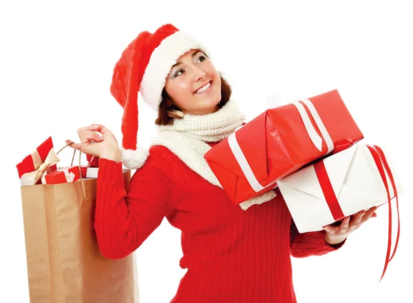 Smiling girl in santa hat with bag full of xmas gift isolated on white background. Stock Picture