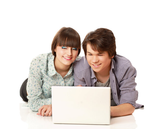 Couple lying on the floor behind a laptop