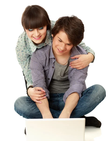 Couple sitting on the floor behind a laptop — Stock Photo, Image