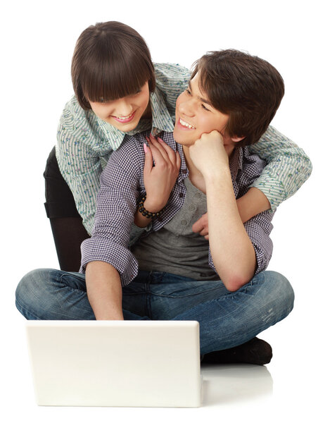 Couple sitting on the floor behind a laptop