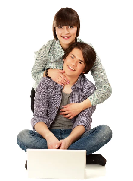 Paar sitzt auf dem Boden hinter einem Laptop — Stockfoto