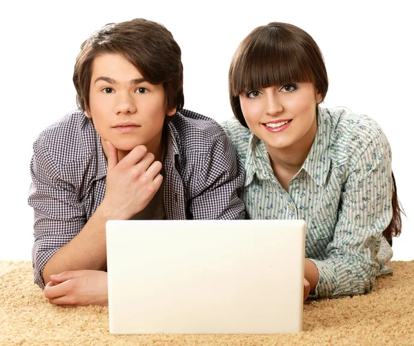 Casal sentado no chão atrás de um laptop — Fotografia de Stock